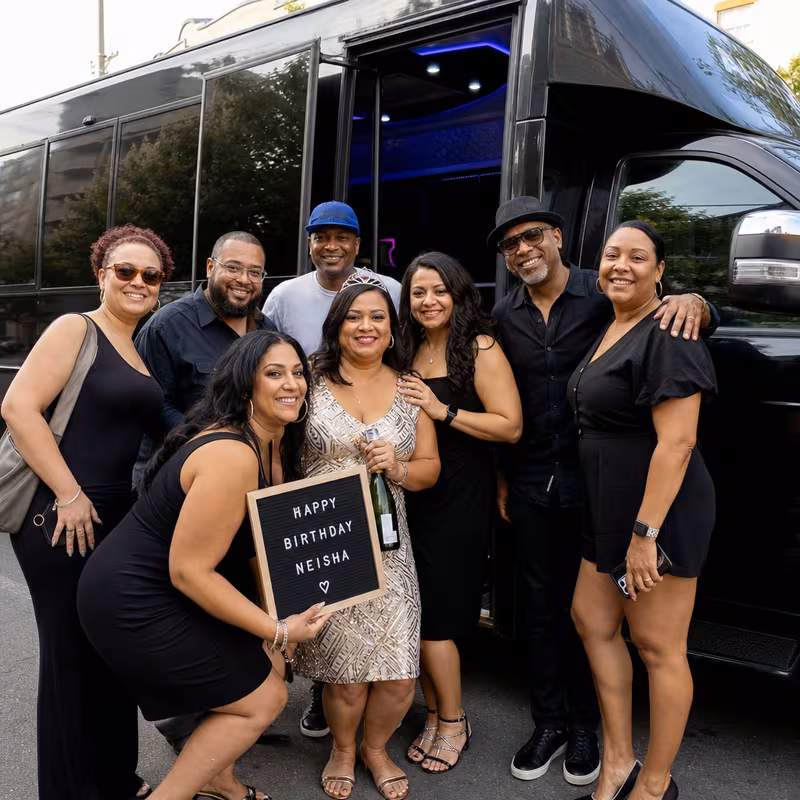 Group boarding a white charter bus for Birthday Transportation transportation in Omaha